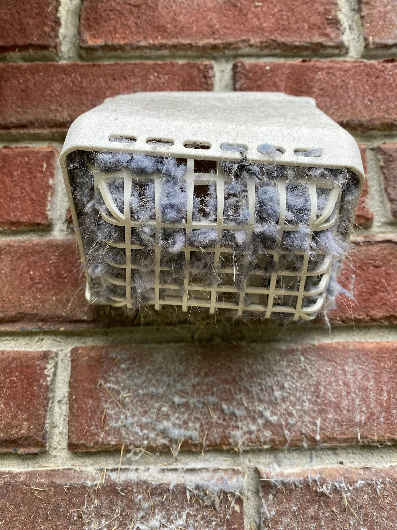 Exterior louvered vent showing dangerous lint accumulation