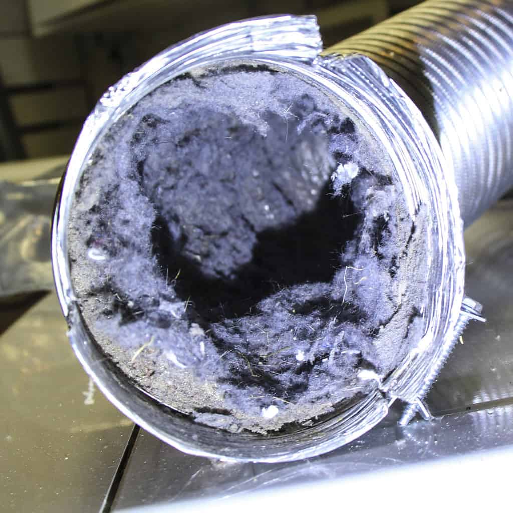 Severely clogged dryer duct showing heavy lint restriction