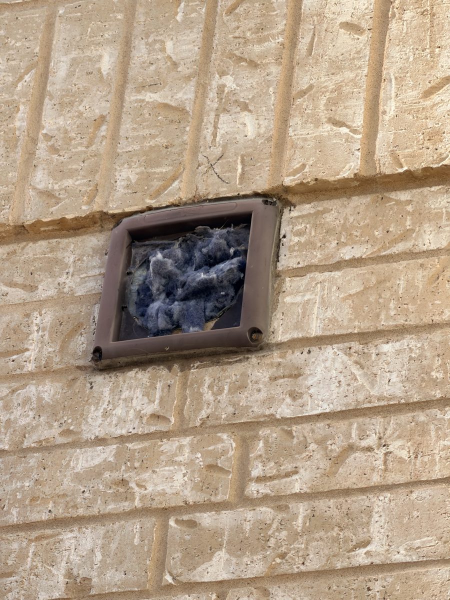 A&D Facility Pros technician servicing a dryer vent